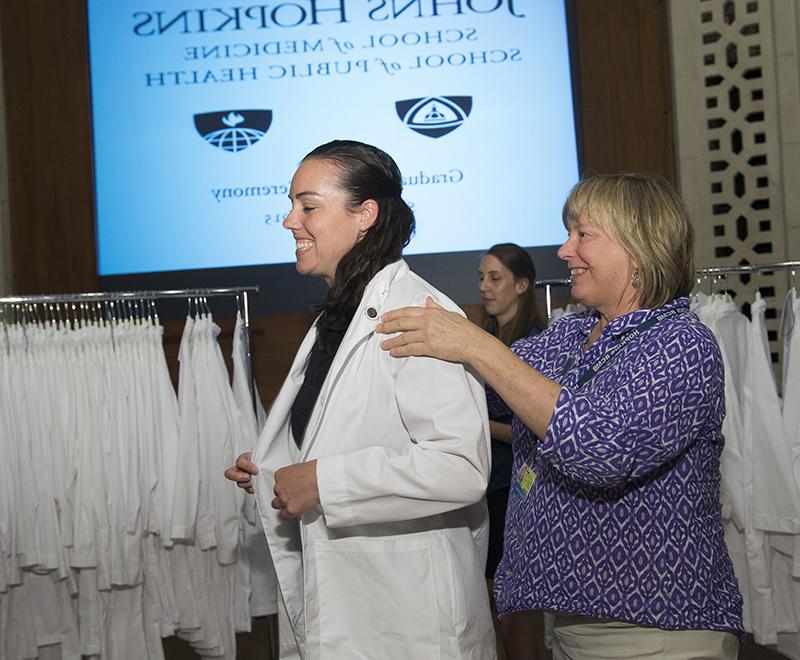A graduate student receives her white coat.